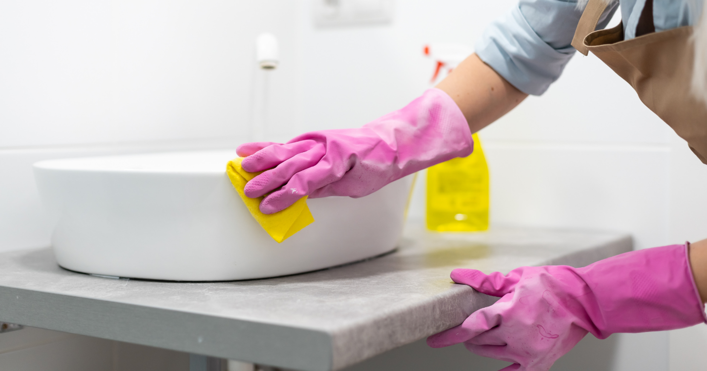 A person cleaning a sink Description automatically generated